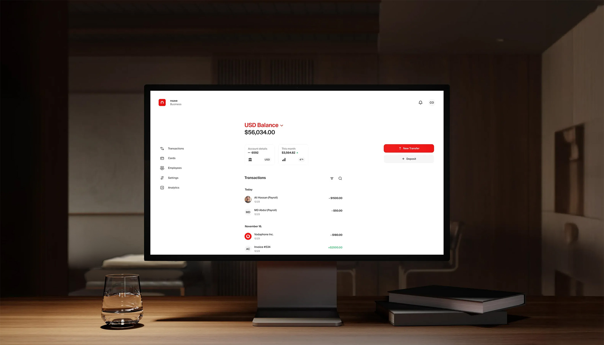 nsave business dashboard showing a USD balance and transactions on a desktop monitor in a warm office